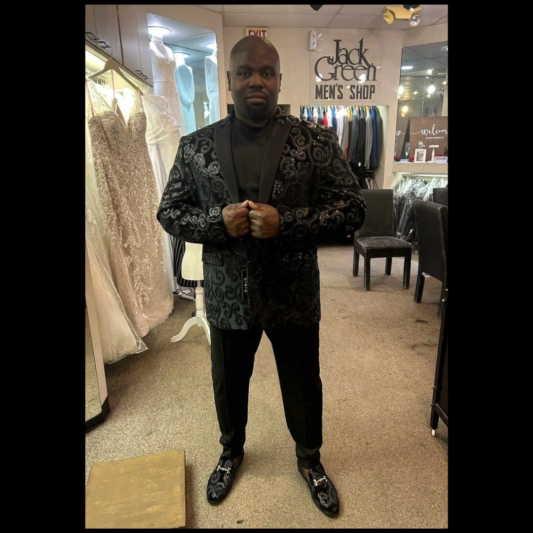 Client in black embroidered swirl blazer with matching patterned loafers