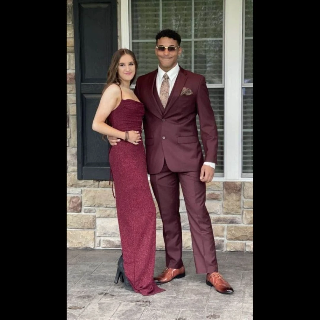 Prom couple in coordinating burgundy - gentleman in suit with paisley tie, date in sparkle gown