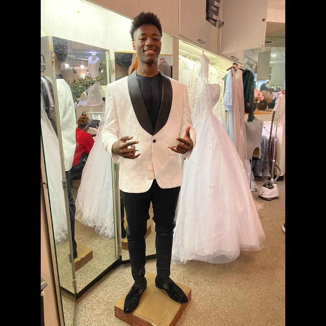 Client in cream textured blazer with black lapel and black sparkle loafers