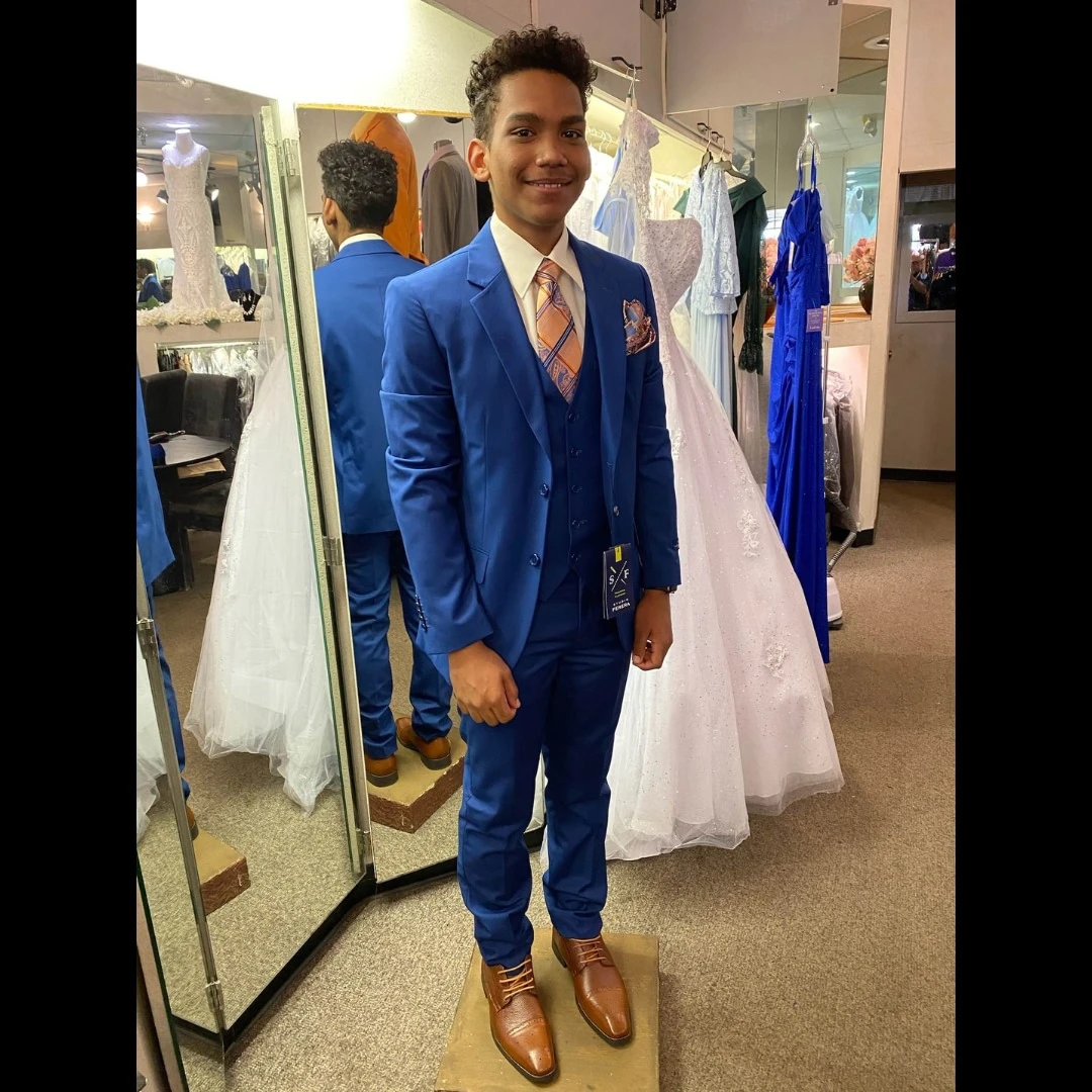 Client in royal blue three-piece suit with orange plaid tie and brown shoes