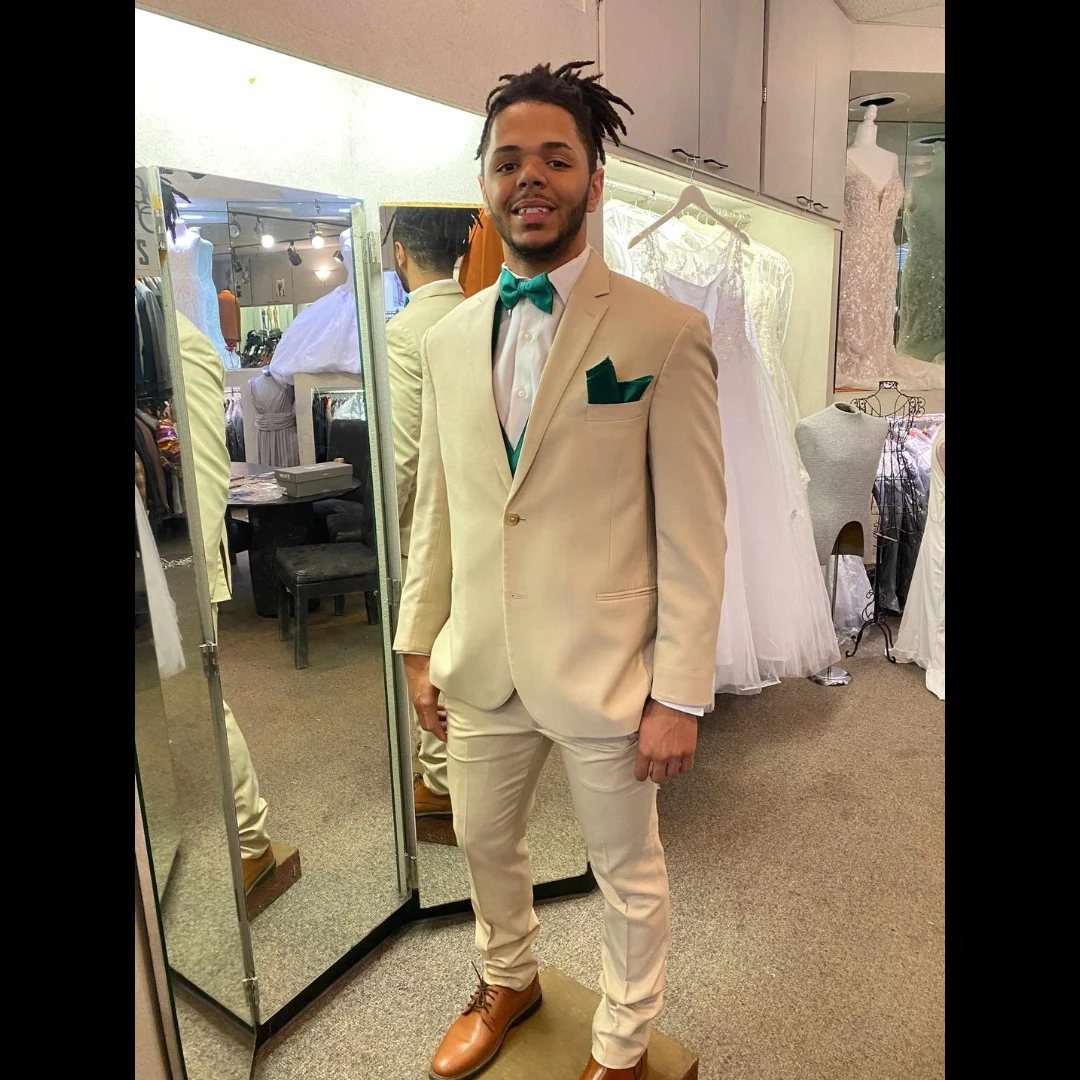 Client in tan suit with teal bow tie and matching pocket square