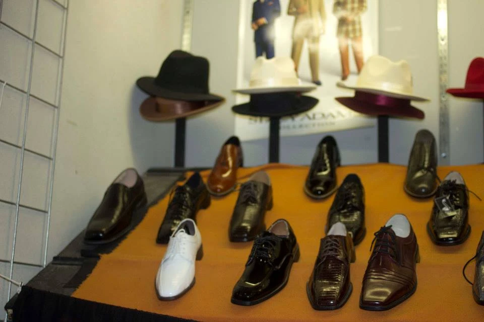 Store display of dress shoes and classic fedora hats