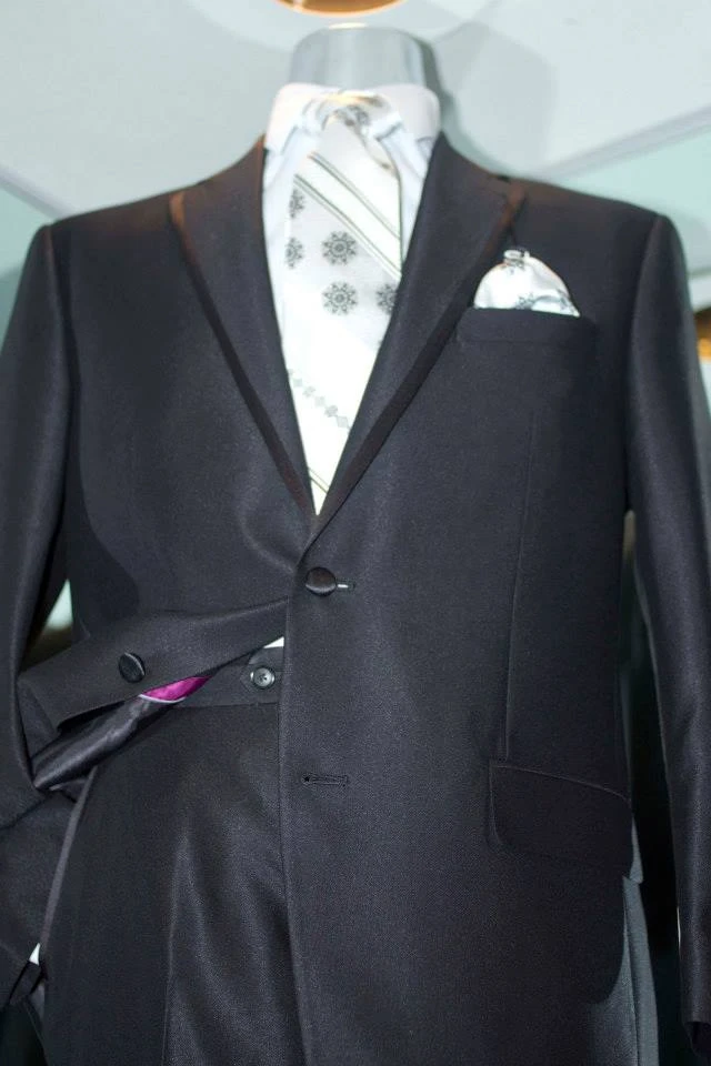 Black suit with white patterned tie and matching pocket square