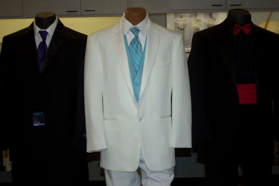 Store display of black and white suits with colorful ties